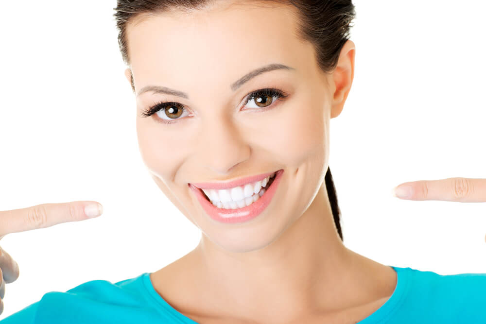 Woman Pointing to White Teeth