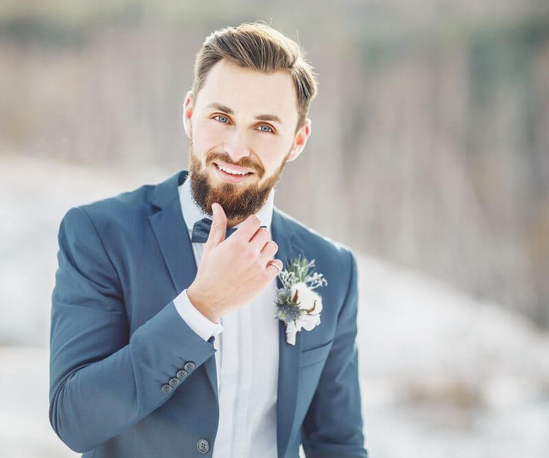 Groom Touching Beard Whilst Smiling