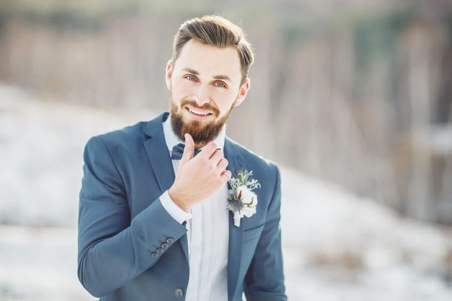 Groom Touching Beard Whilst Smiling
