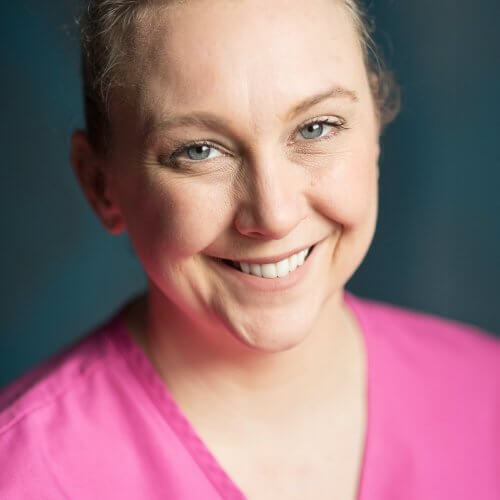 Smiling Dentist in Pink Gown and Blonde Hair